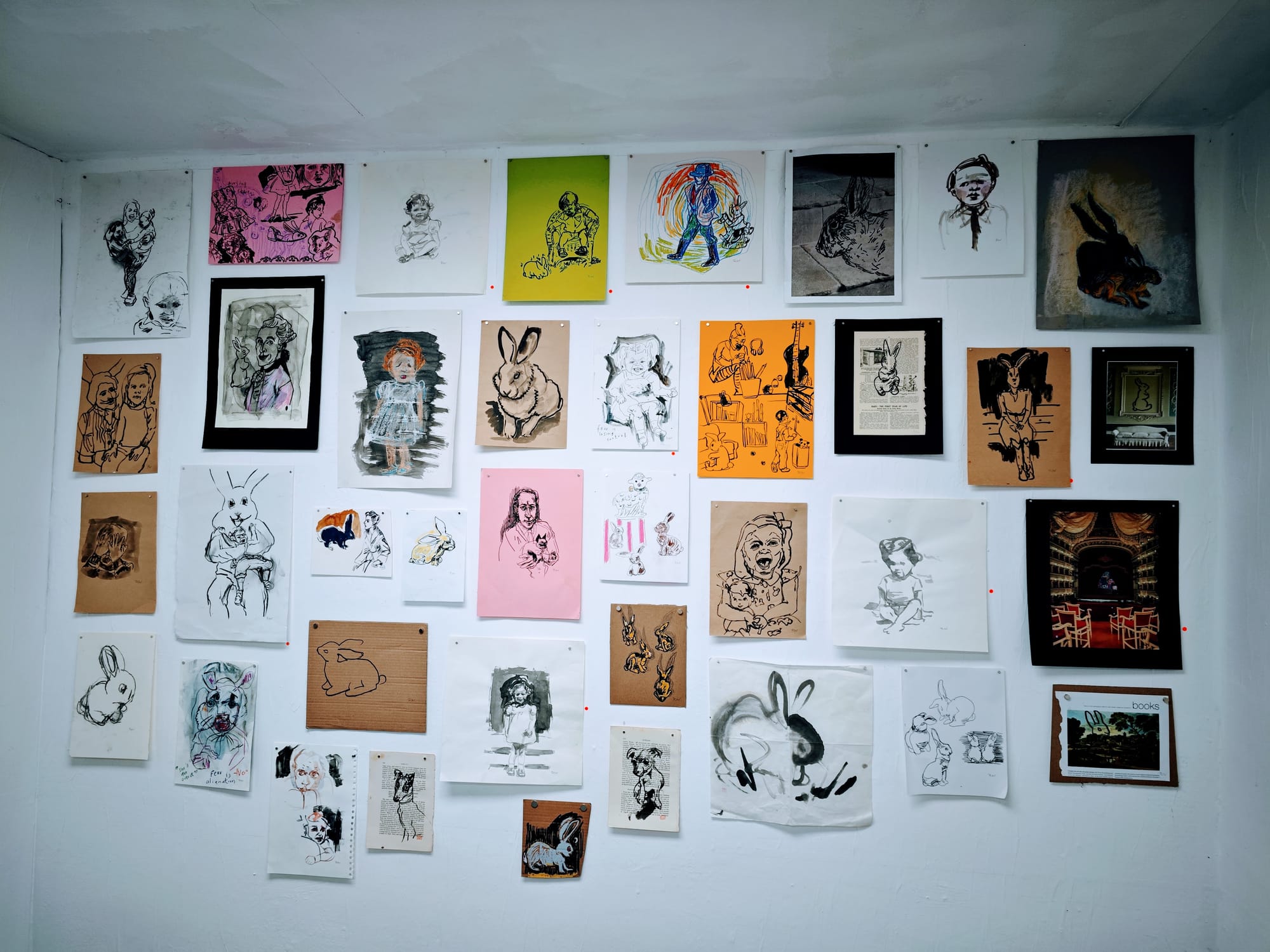 A whimsical gallery wall featuring eclectic drawings and illustrations, many with a recurring rabbit motif.